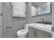 Small bathroom with a gray cabinet and modern fixtures, including a toilet and glass-enclosed shower in the background at 1160 Johnson St, Lakewood, CO 80215