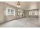 Bright living room with ornate lighting fixtures, plush carpeting and scenic backyard views at 1160 Johnson St, Lakewood, CO 80215