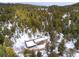 Aerial view of house covered in snow and surrounded by trees at 9034 Us Highway 285, Morrison, CO 80465