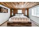 Bedroom featuring a wooden ceiling, plaid throw blanket, and rustic wood furniture at 9034 Us Highway 285, Morrison, CO 80465