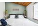 Bright bedroom featuring a wooden ceiling, a bed with white linens, and light green accent walls at 9034 Us Highway 285, Morrison, CO 80465