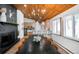 Bright dining area boasts a wood ceiling, modern light fixture, a long black table, and an open connection to the kitchen at 9034 Us Highway 285, Morrison, CO 80465