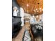 Open-concept dining room with modern chandelier, wood ceiling, fireplace, and kitchen bar seating at 9034 Us Highway 285, Morrison, CO 80465