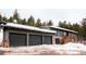 Home exterior featuring a three-car garage with an elevated walkway at 9034 Us Highway 285, Morrison, CO 80465