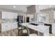 Bright kitchen boasts white cabinets, granite countertops, and an island with seating at 4686 Longs Ct, Broomfield, CO 80023