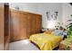Bedroom has built in wooden closet and wall art above bed with bright yellow floral patterned comforter at 3377 Blake St # 205, Denver, CO 80205