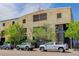 Exterior view of the industrial-style building with parking and landscaping at 3377 Blake St # 205, Denver, CO 80205