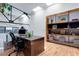 Bright office features a wooden desk, shelves, hardwood floors, and an industrial-style ceiling and beams at 3377 Blake St # 205, Denver, CO 80205