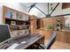 Stylish office has a built in shelving unit, plants, a wooden desk and industrial-style ceiling with beams at 3377 Blake St # 205, Denver, CO 80205