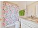 Well-lit bathroom with white vanity, granite countertop, patterned shower curtain and tile flooring at 1918 Depew St, Lakewood, CO 80214