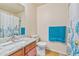 Bathroom features a granite countertop sink, toilet, and shower with a blue and white curtain at 1918 Depew St, Lakewood, CO 80214
