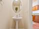 Half bathroom with pedestal sink, mirror, and decorative wall art at 1918 Depew St, Lakewood, CO 80214