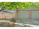 View of a two car garage featuring a brick facade and a wooden fence at 1918 Depew St, Lakewood, CO 80214