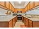Well-lit kitchen with light granite countertops, stainless steel appliances, and wood cabinetry at 1918 Depew St, Lakewood, CO 80214
