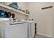 Laundry room with modern washer and dryer units, overhead shelving, and tiled floor at 1918 Depew St, Lakewood, CO 80214