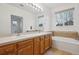 Bathroom featuring double sinks, a large mirror, and a bathtub at 11391 Navajo Cir # B, Westminster, CO 80234
