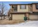 A townhouse with a two-car garage, stone accents, and a second-story balcony at 11391 Navajo Cir # B, Denver, CO 80234