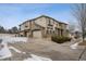 A row of townhouses with two-car garages, stone accents, and a snowy driveway at 11391 Navajo Cir # B, Westminster, CO 80234
