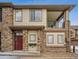 Attractive two-story condo featuring a red door, stone accents, and a balcony on the second floor at 11391 Navajo Cir # B, Westminster, CO 80234