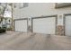 Attached two-car garages with stone accents and individual unit numbers displayed above at 10381 Cook Way # 202, Thornton, CO 80229
