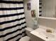 Neat bathroom with black and white striped shower curtain and fun comic art at 8757 W 75Th Way, Arvada, CO 80005