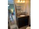 Bathroom vanity featuring dark wood, granite countertops, and a decorative mirror at 8757 W 75Th Way, Arvada, CO 80005