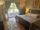 Bedroom with wooden floors, a large bed, dresser, and sliding doors to the outside deck at 8757 W 75Th Way, Arvada, CO 80005