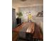 Charming dining room with a wooden table, hardwood floors, and exposed brick wall with decorative lighting at 8757 W 75Th Way, Arvada, CO 80005