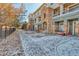 Townhome exterior featuring stone accents, patios, and snowy sidewalks at 494 Black Feather Loop # 117, Castle Rock, CO 80104