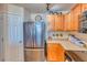 Kitchen featuring stainless steel refrigerator, wood cabinets and drawers, with light countertops at 494 Black Feather Loop # 117, Castle Rock, CO 80104