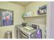 Laundry room with modern washer and dryer, shelving, and Texas wall art at 494 Black Feather Loop # 117, Castle Rock, CO 80104
