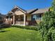 Inviting home exterior featuring a covered front porch, manicured lawn, and classic design elements at 221 Homestead Pkwy, Longmont, CO 80504