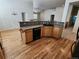 Functional kitchen layout featuring a breakfast bar, dark appliances, and wooden cabinetry at 221 Homestead Pkwy, Longmont, CO 80504