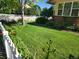 A lush green lawn with landscaped garden beds and a white picket fence creates a picturesque outdoor space at 221 Homestead Pkwy, Longmont, CO 80504