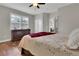 Comfortable bedroom with hardwood floors, dresser, ceiling fan, and bright window with plantation shutters at 4822 Pathfinder Ct, Castle Rock, CO 80108