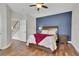 Comfortable bedroom featuring a ceiling fan, an accent wall, and hardwood floors at 4822 Pathfinder Ct, Castle Rock, CO 80108