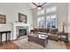Inviting living room featuring a stone fireplace, ceiling fan, and ample natural light from large windows at 4822 Pathfinder Ct, Castle Rock, CO 80108