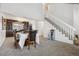 Open-concept dining area featuring a carpeted floor, a staircase, and a table set for six in a cozy space at 5895 S Killarney Way, Centennial, CO 80015
