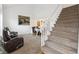 Spacious living room with a dining area, featuring carpet floors and a staircase with white banisters at 5895 S Killarney Way, Centennial, CO 80015
