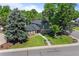 Aerial view of a two-story brick and siding home, a well-manicured lawn, mature trees, and a tree swing at 5081 S Emporia St, Greenwood Village, CO 80111
