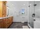 The modern bathroom features wood cabinetry, black hardware and hexagon tile floors at 5081 S Emporia St, Greenwood Village, CO 80111