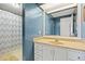 Cozy bathroom featuring a shower and sink with textured walls at 5081 S Emporia St, Greenwood Village, CO 80111