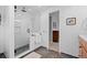 Modern bathroom with white tiled shower, grey hexagon tile floor and wood vanity at 5081 S Emporia St, Greenwood Village, CO 80111
