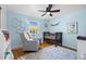 Light blue bedroom with a ceiling fan, crib, rocking chair, and hardwood floors at 5081 S Emporia St, Greenwood Village, CO 80111
