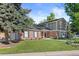 Charming two-story home with brick and siding exterior, mature trees, a well-manicured lawn, and a three car garage at 5081 S Emporia St, Greenwood Village, CO 80111