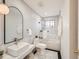 Modern bathroom featuring a soaking tub, stylish vanity, and black and white tile accents at 6585 E Nevada Pl, Denver, CO 80224