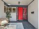 Inviting front porch with a red door and modern screen door, perfect for relaxing and enjoying the outdoors at 6585 E Nevada Pl, Denver, CO 80224