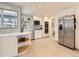 Well-lit kitchen with white cabinetry, stainless steel appliances, open shelving, and modern backsplash at 6585 E Nevada Pl, Denver, CO 80224