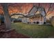 A spacious backyard with a covered patio, mature tree, and lush lawn, perfect for outdoor activities at 12028 W Aqueduct Dr, Littleton, CO 80127