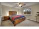 Comfortable bedroom featuring a wooden bed frame, ceiling fan, and ample natural light from the window at 12028 W Aqueduct Dr, Littleton, CO 80127